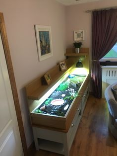 a living room filled with furniture and a fish tank on top of a counter next to a window