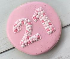 a pink cake with white and pink sprinkles in the shape of the number twenty