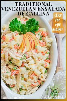 a white bowl filled with pasta salad and topped with an apple slice next to a wooden spoon