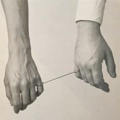 two hands are pulling something on a string with one hand and the other holding another