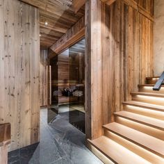 there is a staircase leading up to the bedroom in this wooden house with wood paneling on the walls