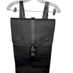 a black backpack hanging on a white hanger with clothes pins and clips attached to it