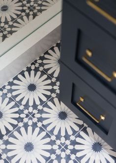 a black and white tiled floor next to a drawer with drawers on top of it