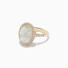 a white opal and diamond ring with yellow gold band, set on a white background