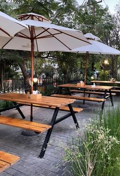 an outdoor dining area with tables and umbrellas