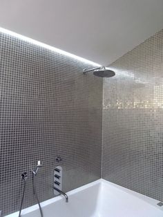 a white bath tub sitting next to a shower head