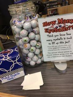 a jar full of baseballs sitting on top of a desk next to a sign that says how many eyeballs?