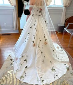 a woman in a wedding dress looking at herself in the mirror