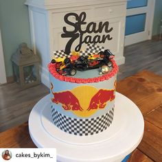 a birthday cake with cars on it sitting on top of a table