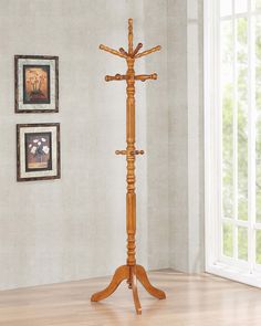 a wooden coat rack with three crosses on it in front of a white wall and hardwood floor