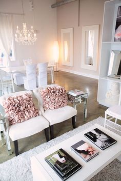 a living room with two white couches and a coffee table in front of it