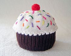 a knitted cupcake with sprinkles and a cherry on top