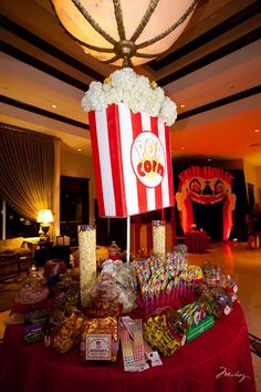 a table with popcorn, candy bar carnival theme and other items on it for sale