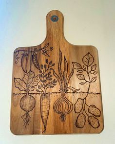 a cutting board with vegetables drawn on the front and sides, sitting on a wall