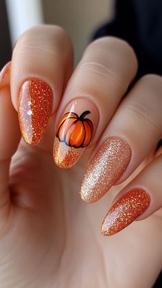 Sparkle this fall with Pumpkin with Glitter Accent nails! The shimmering glitter adds a festive touch to the classic pumpkin design, perfect for autumn. Click to see more and follow us for fresh nail inspiration! #PumpkinGlitter #FallNailArt #AutumnStyle #NailDesigns #SeasonalNails Autumn Nails Acrylic Almond, Fall Nail Art Pumpkin, Fall Nails With A Pumpkin, Easy Fall Acrylic Nails, Nail Art With Pumpkins, Coast Nails, Pumpkin Nail Designs Fall, Pumpkin Designs Nails, Nail Art Pumpkin