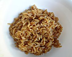 a white bowl filled with brown rice on top of a table