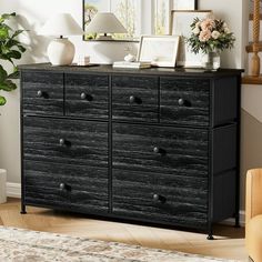 a black dresser with drawers and pictures on top