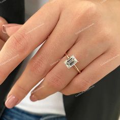 a woman's hand with a ring on her finger and a diamond in the middle