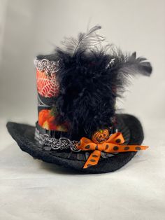 Lightweight and very easy to wear, it can easily be positioned and secured at the appropriate angle, with two alligator clips, hidden from sight. Brim made with fabric and wire so its easy to bend to adjust to head. This mini hat is 3 1/2 inches tall. Perfect hat to complete your Halloween look! This hat is ready to ship only in the U.S. because of the feathers. Please contact me with any questions you might have. Follow me on Facebook and Instagram. https://www.facebook.com/EleyasDesigns/ https Novelty Black Brimmed Mini Hats, Themed Adjustable Top Hat With Curved Brim, Halloween Adjustable Top Hat With Short Brim, Halloween Top Hat With Short Brim, Adjustable Mini Hats With Short Brim For Halloween, Themed Mini Hat With Adjustable Short Brim, Themed Adjustable Mini Hat With Short Brim, Halloween Hats Diy, Diy Mad Hatter Hat