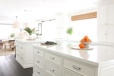 a kitchen with white cabinets and counter tops