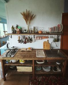 a wooden table topped with lots of bowls and pans next to a stove top oven