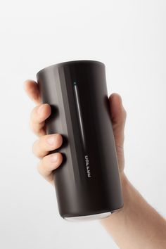 a hand holding a black coffee cup in front of a white background with the lid up