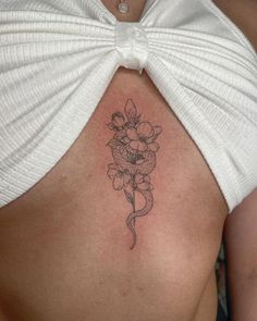 a woman with a tattoo on her stomach has a flower in the shape of a bow