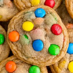 cookies with m & m candies and chocolate chips are piled on top of each other