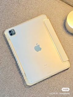 an apple ipad sitting on top of a couch next to a charger