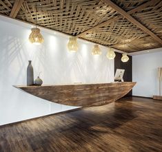 a large wooden table sitting on top of a hard wood floor next to a white wall