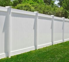 a white vinyl fence in the grass