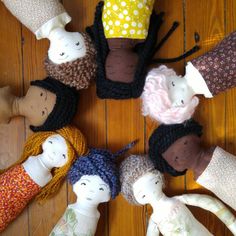 a group of dolls sitting on top of a wooden floor next to each other in the middle of a circle