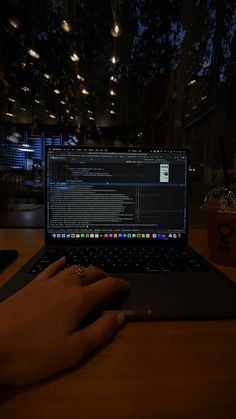 a person is typing on their laptop in the dark