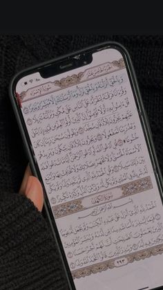 someone is holding their cell phone with an arabic text on it