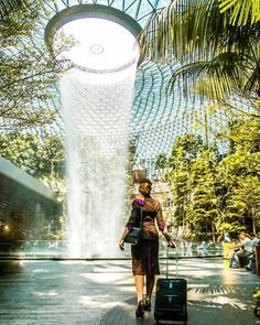 air hostess standing in front of the rain vortex at the jewel in Singapore Changi Airport Art Science Museum, Places In Singapore, Waterfall Lights, Singapore Botanic Gardens, Changi Airport, Annual Leave, Indoor Waterfall, Most Instagrammable Places, Orchids Garden