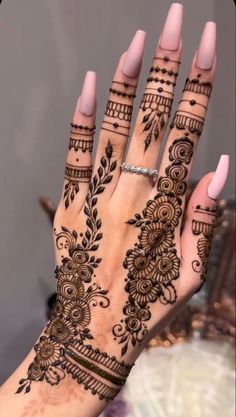 a woman's hand with henna tattoos on it