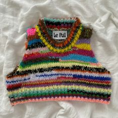 a vest made out of multicolored knits on a white sheet with a label that says le pull