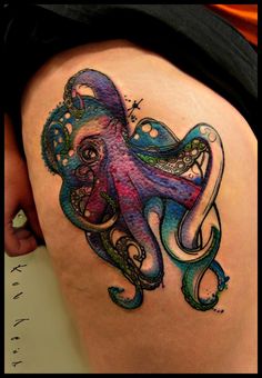 an octopus tattoo on the back of a woman's thigh, with colorful ink