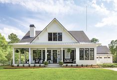 a white house sitting on top of a lush green field