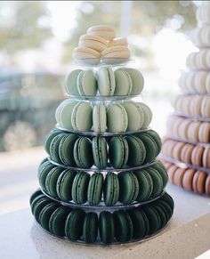 a stack of green and white macaroons sitting on top of a counter next to each other