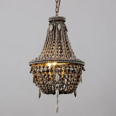 a chandelier hanging from a chain with beads and shells on it's sides