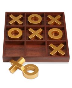 a tic - tac - toe set with two gold rings and an xo symbol