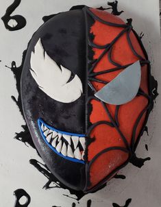 a spiderman cake with black icing and white sprinkles on it