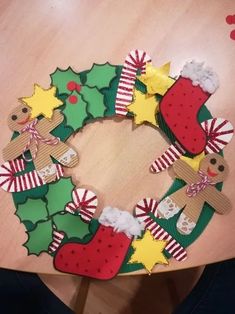 a christmas wreath made out of paper on top of a wooden table