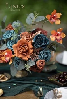 a bouquet of flowers sitting on top of a table next to a knife and fork