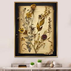 an old book with dried flowers and leaves on it is hanging above a table in a room