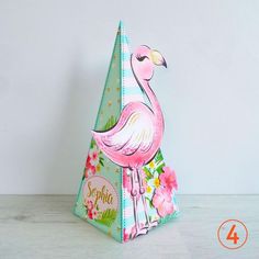 a pink flamingo standing on top of a paper cone with flowers and leaves around it