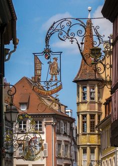 the clock tower is on top of the building next to the people walking down the street