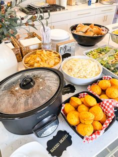 an assortment of food is displayed on a kitchen counter with bowls, plates and utensils