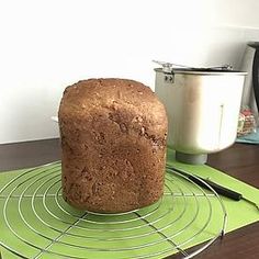 a loaf of bread sitting on top of a cooling rack next to a pot and knife